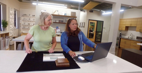 2 people comparing countertop and tile samples for a kitchen.
